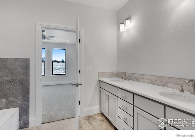 bathroom with a tub, tile patterned flooring, ceiling fan, and vanity