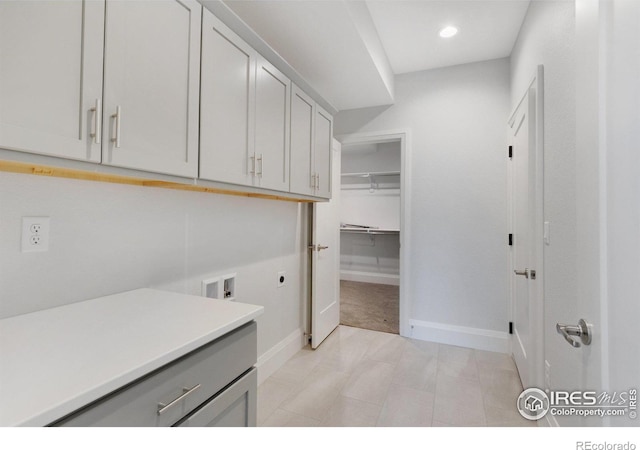 laundry area with electric dryer hookup, hookup for a washing machine, and cabinets