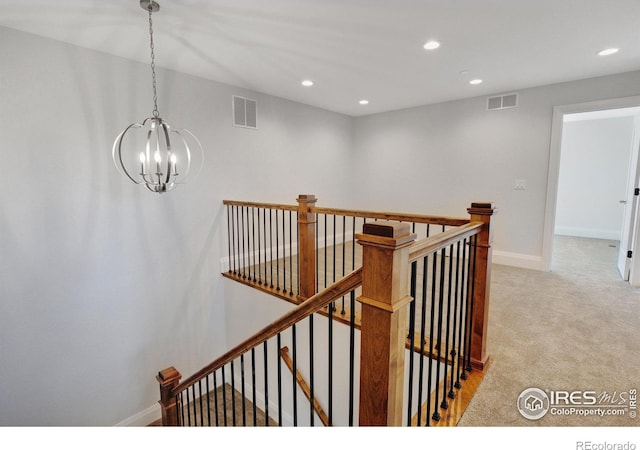 staircase featuring a notable chandelier and carpet flooring