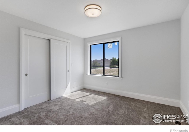 unfurnished bedroom with a closet and carpet flooring