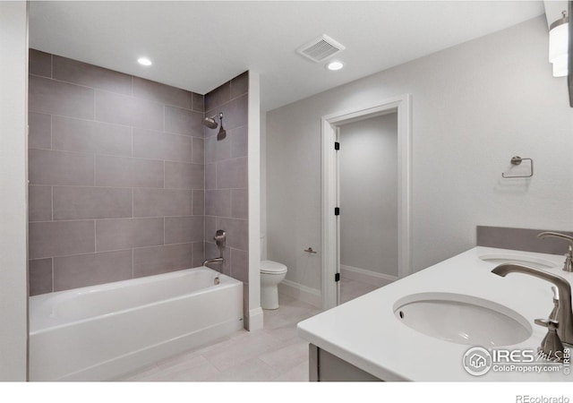 full bathroom featuring toilet, tiled shower / bath, tile patterned floors, and vanity