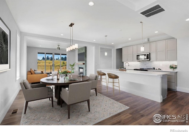 dining room featuring sink and dark hardwood / wood-style flooring