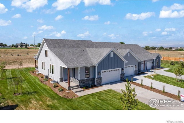 5700 2nd Street Rd, Greeley, CO 80634 - view of front of house featuring board and batten siding, driveway, an attached garage, roof with shingles, and stone siding