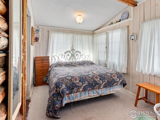 bedroom featuring wooden walls and carpet