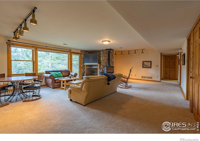 carpeted living room featuring a fireplace and track lighting