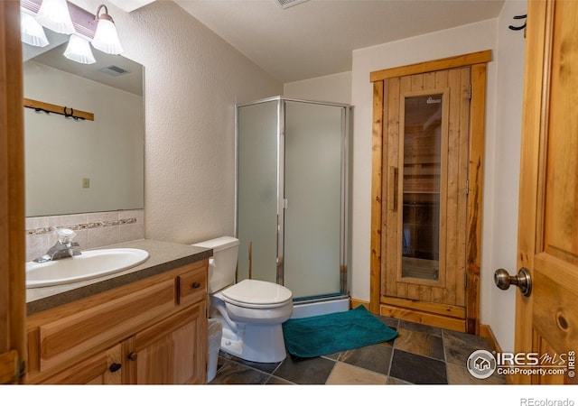 bathroom featuring a shower with door, tile patterned floors, toilet, and vanity