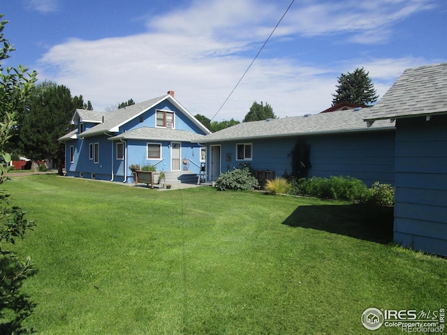 back of house with a yard and a patio