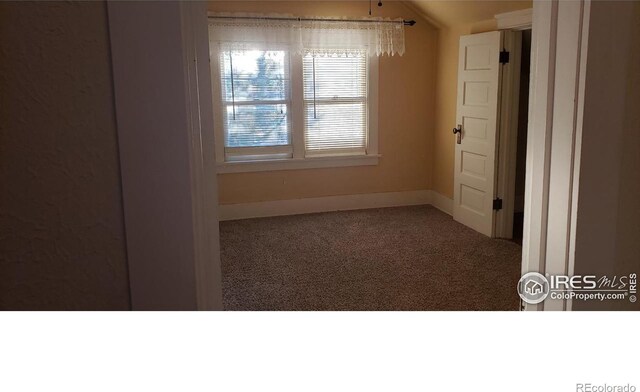 unfurnished room featuring vaulted ceiling and carpet flooring