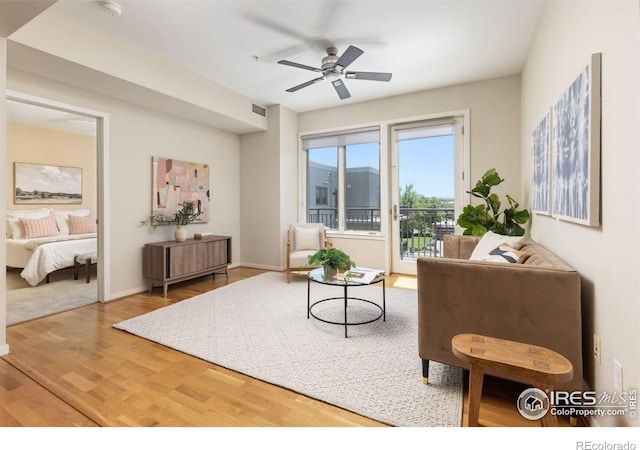 living room featuring wood-type flooring and ceiling fan