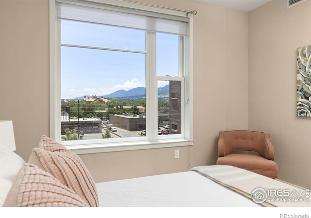 bedroom with multiple windows and a mountain view