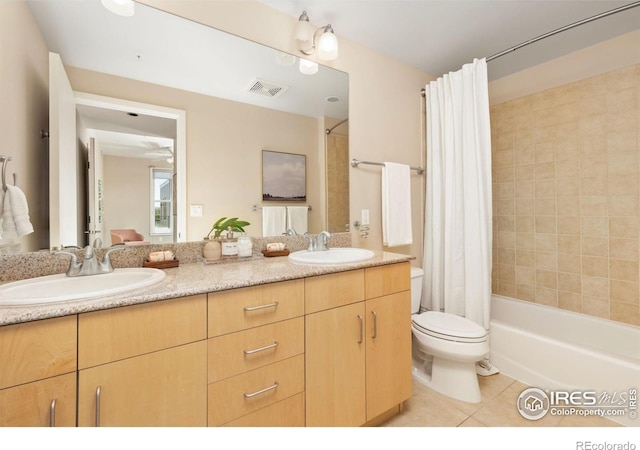 full bathroom featuring tile patterned floors, ceiling fan, shower / bath combination with curtain, dual vanity, and toilet