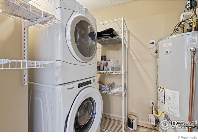 laundry area featuring stacked washer and clothes dryer, water heater, and tile patterned floors