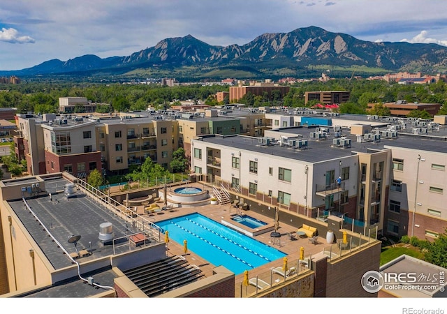 view of pool with a mountain view and a hot tub