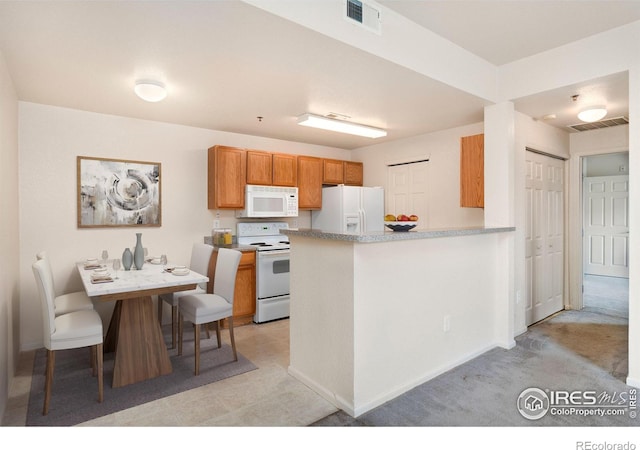 2990 W C St Unit 103, Greeley, CO 80631 - kitchen with white appliances, a peninsula, baseboards, brown cabinets, and light countertops