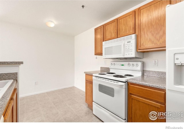 kitchen featuring white appliances and light tile patterned flooring