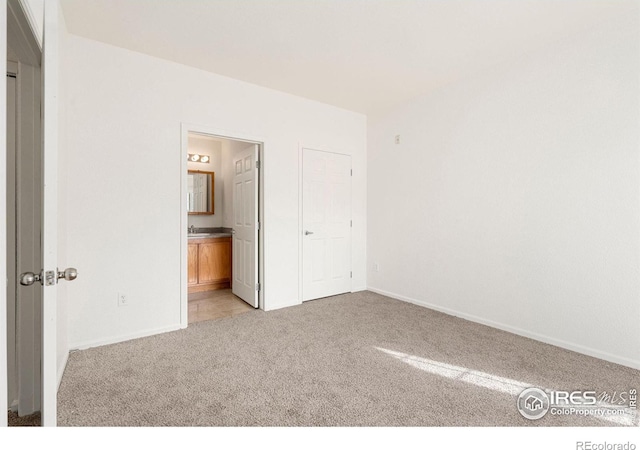 2990 W C St Unit 103, Greeley, CO 80631 - unfurnished bedroom featuring light carpet, baseboards, and ensuite bath