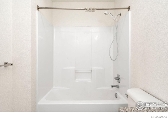 2990 W C St Unit 103, Greeley, CO 80631 - bathroom with washtub / shower combination, toilet, and a textured wall