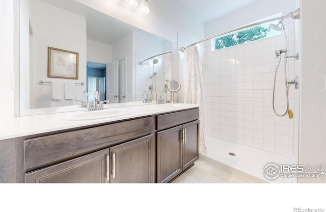 bathroom featuring tile patterned flooring, vanity, and walk in shower