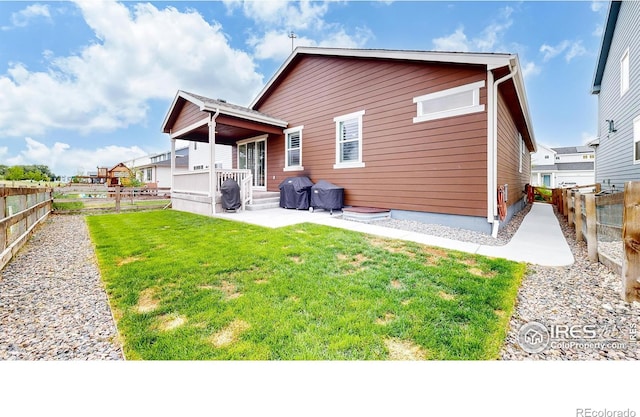 rear view of property featuring a patio area and a yard