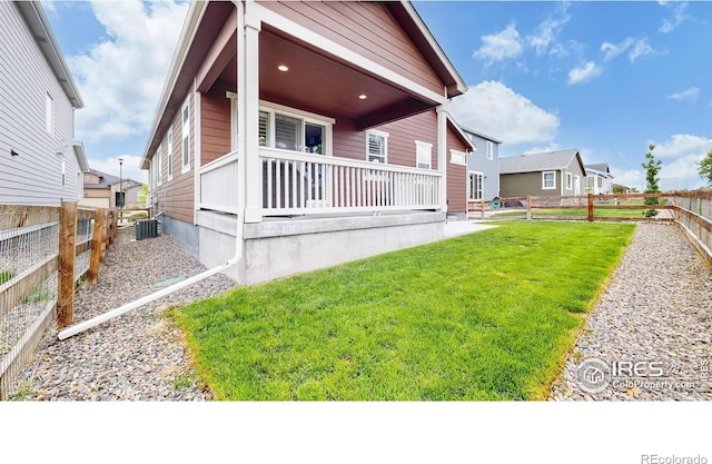 back of house featuring a yard and central AC unit