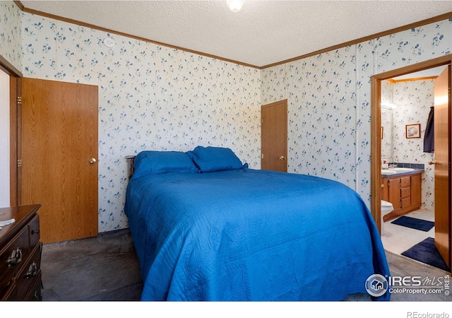 carpeted bedroom with ensuite bath, a textured ceiling, and crown molding