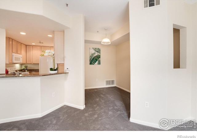 kitchen with decorative light fixtures, light brown cabinets, and dark carpet