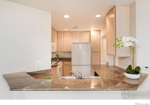 kitchen featuring kitchen peninsula, light brown cabinets, white appliances, and sink