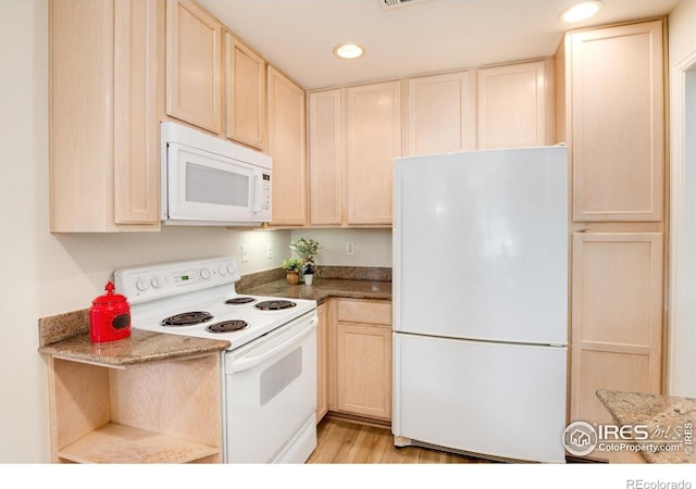 kitchen featuring light brown cabinets, white appliances, dark stone counters, and light hardwood / wood-style flooring