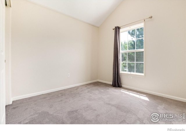 spare room with carpet floors and lofted ceiling