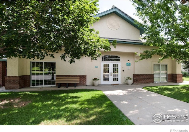 view of front of house with a front yard and french doors