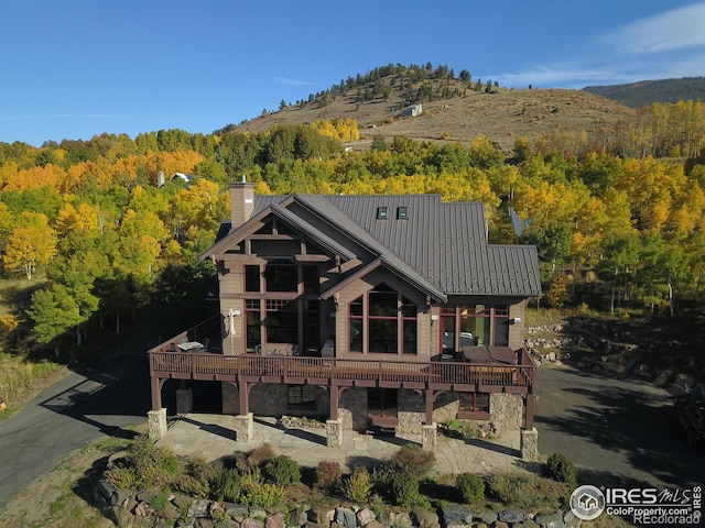 back of property featuring a wooden deck and a patio area