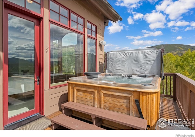 balcony with a deck with mountain view and a hot tub