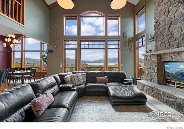 living room with a fireplace, an inviting chandelier, a mountain view, and plenty of natural light