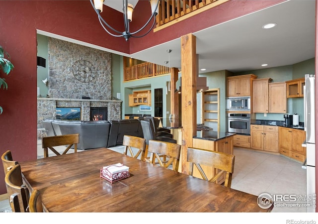 dining space featuring a fireplace and an inviting chandelier