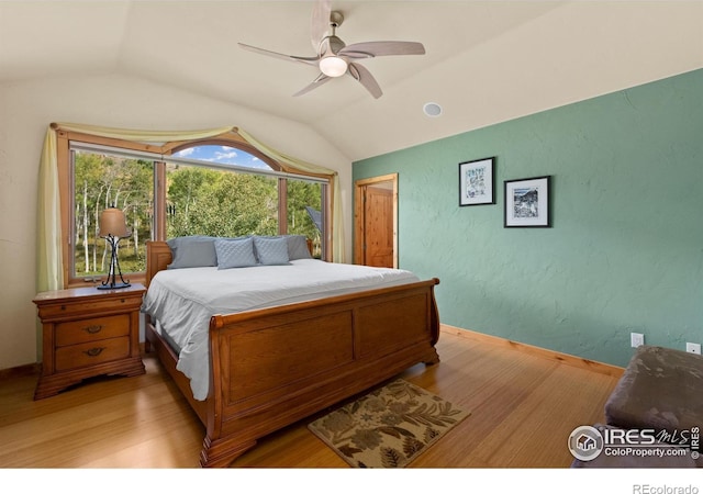 bedroom featuring light hardwood / wood-style floors, ceiling fan, and vaulted ceiling