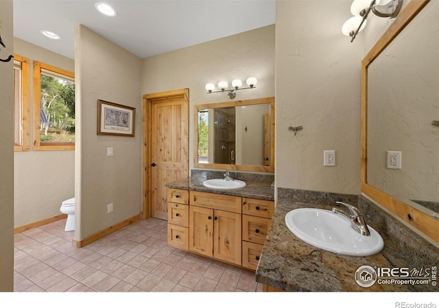 bathroom featuring walk in shower, tile patterned flooring, vanity, and toilet