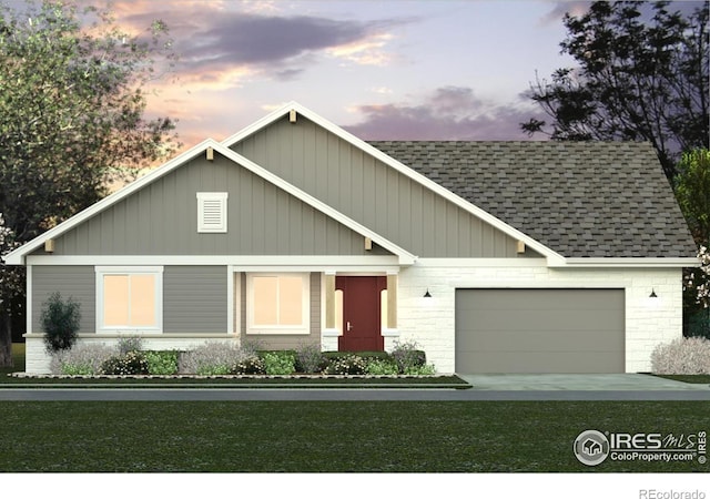 view of front of home with a garage and a yard