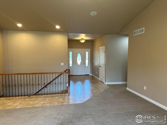 carpeted entrance foyer with vaulted ceiling