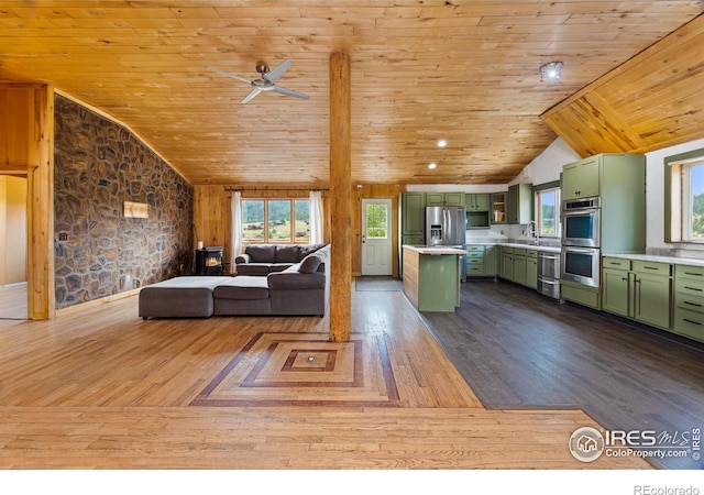 unfurnished living room featuring vaulted ceiling, plenty of natural light, and wood finished floors