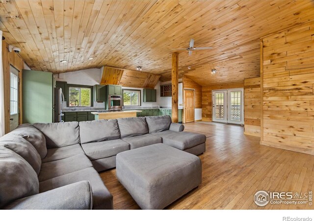 living room with light hardwood / wood-style flooring, wood ceiling, and plenty of natural light