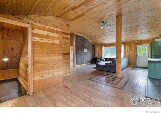 interior space featuring lofted ceiling, wood walls, ceiling fan, light hardwood / wood-style floors, and wooden ceiling