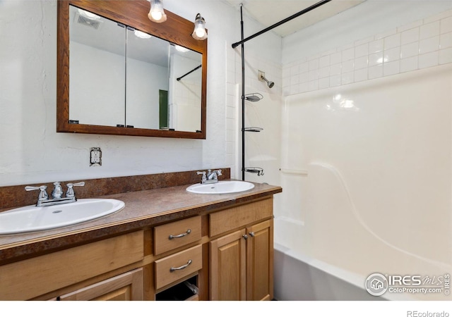 bathroom featuring dual vanity and shower / bathing tub combination