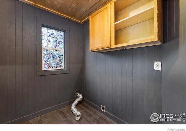 laundry room featuring dark wood-type flooring and cabinets