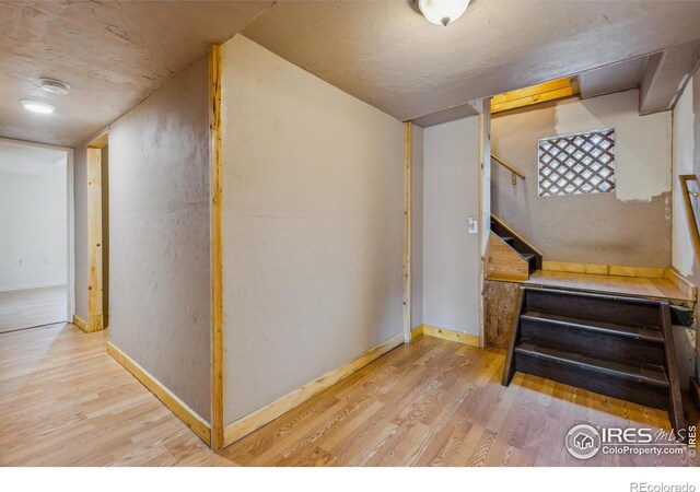 stairway with light hardwood / wood-style floors