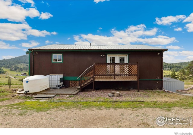 rear view of house featuring french doors and a deck with mountain view