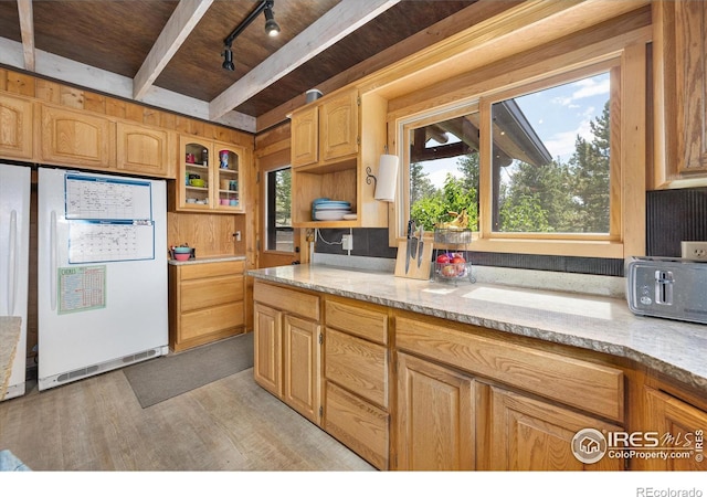 kitchen with wooden walls, white refrigerator, wooden ceiling, beamed ceiling, and light wood-type flooring