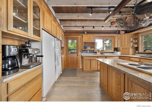 kitchen with beamed ceiling, rail lighting, sink, white fridge, and light wood-type flooring