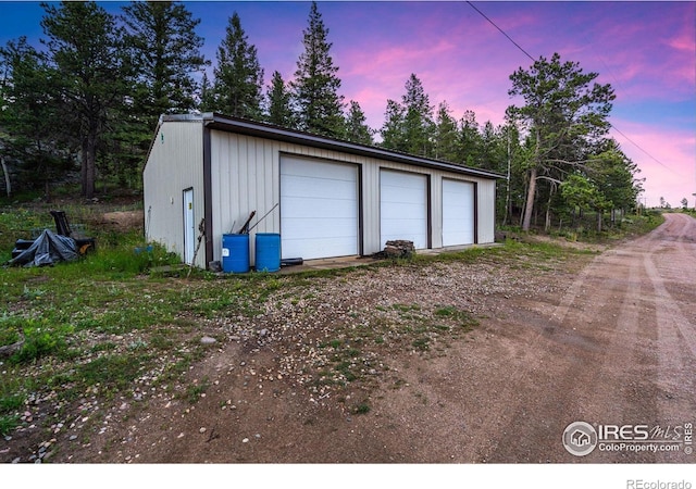 view of garage at dusk