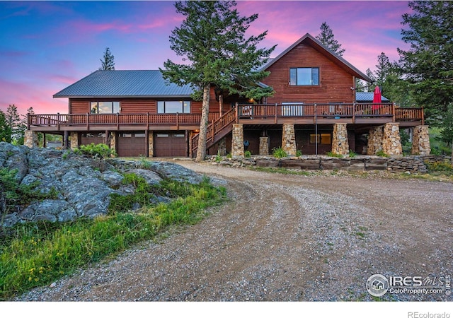 log-style house featuring a wooden deck and a garage