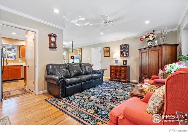 living room featuring ceiling fan, ornamental molding, and light hardwood / wood-style floors